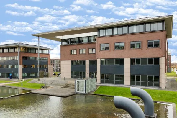 Modern kantoorgebouw aan de Boris Pasternaklaan met waterpartij en opvallende ventilatiebuizen op de voorgrond.
